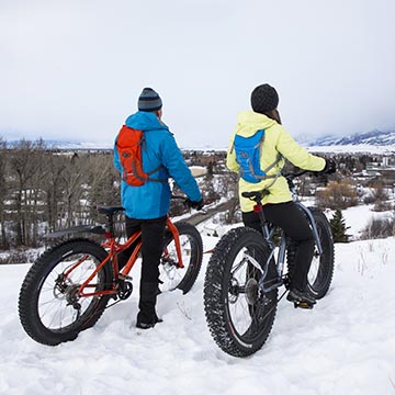 couple mountain biking in snow