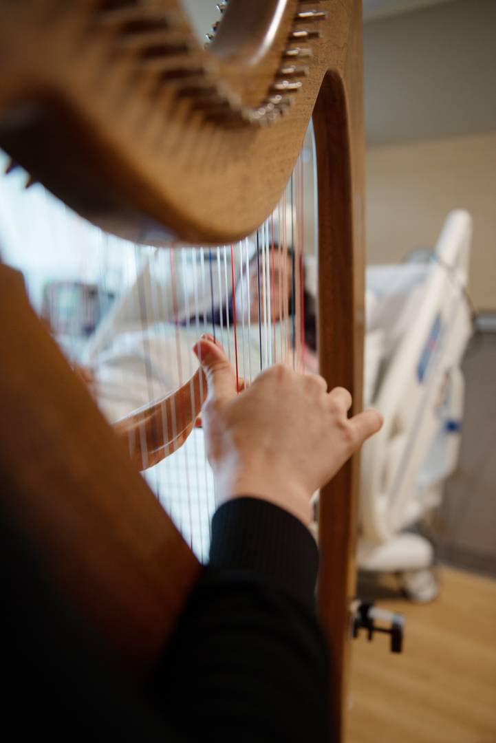 Person playing harp for patient